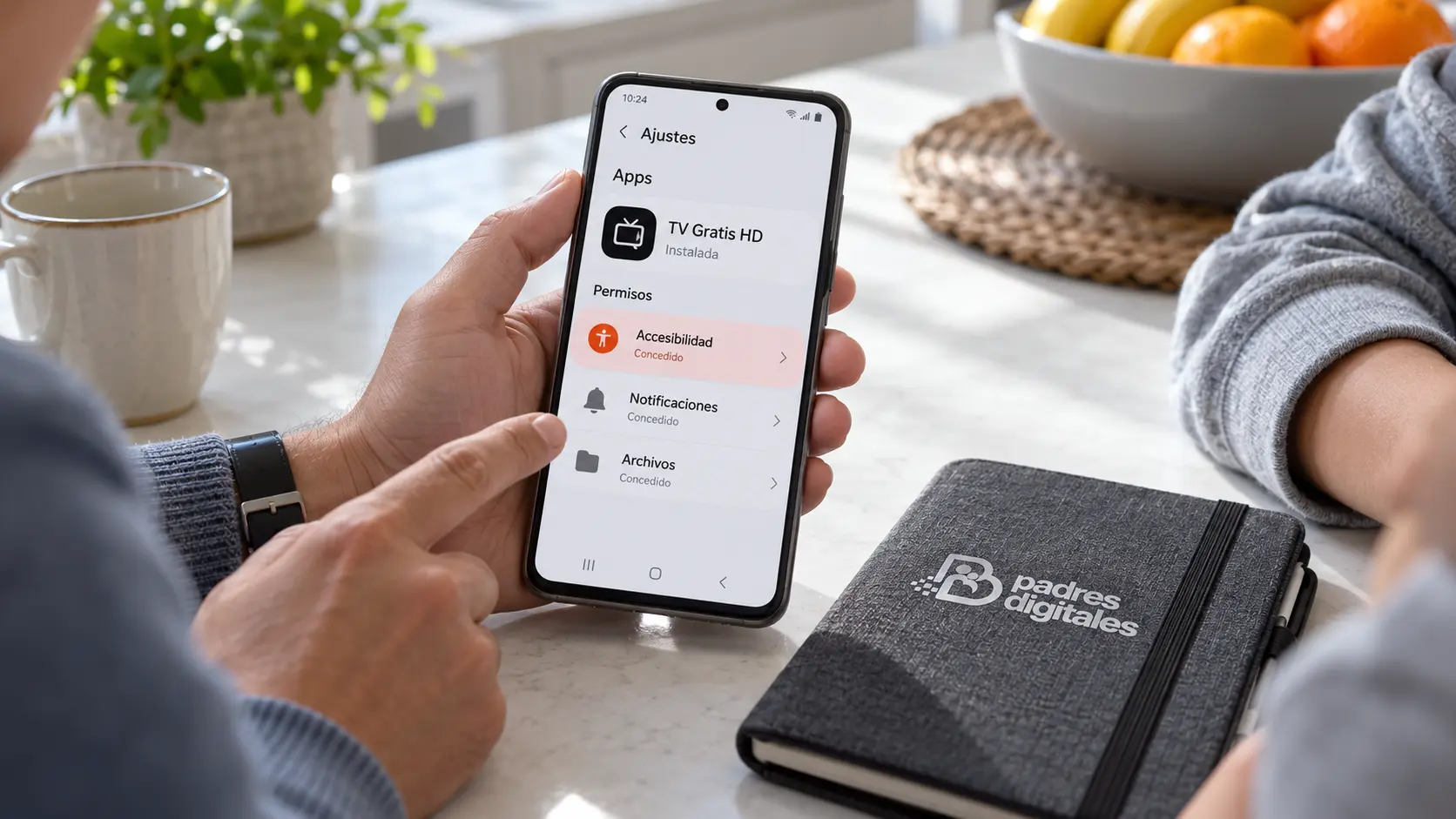 Familia revisando permisos de una app Android sospechosa con accesibilidad concedida